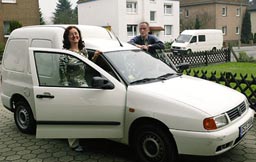 Ein Foto der Geschäftsführung von Kaps Transporte, die an einem der Firmenfahrzeuge stehen.